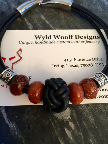 Leather cord bracelet, black leather, beaded goldstone beads and black eternity knot center piece,